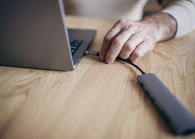 Mężczyzna podłącza hub USB-C do laptopa